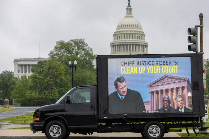 A mobile billboard showing Supreme Court Chief Justice Roberts passes the U.S. Capitol on Friday.
