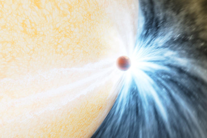 An artist's impression of an aging star swelling up and beginning to engulf a planet, much like the Sun will do in about 5 billion years.