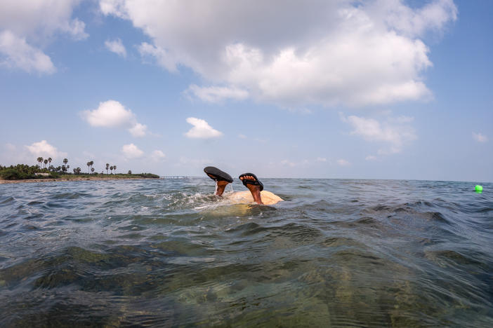 Thangamma, about 80 years old, dives in to gather seaweed.