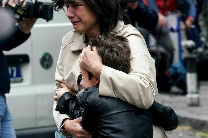 A parent escorts her child following a shooting at a school in the capital Belgrade on Wednesday.