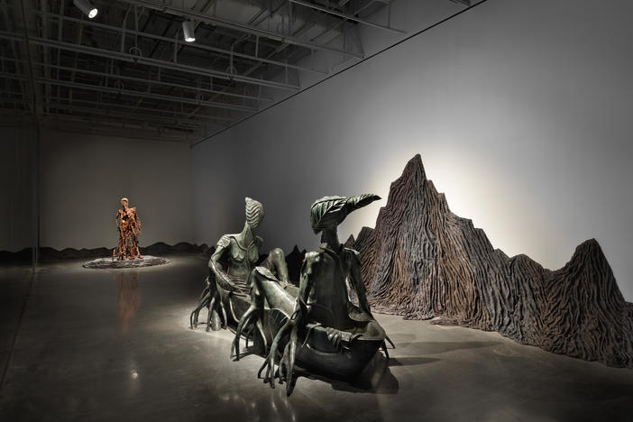Visitors to "Wangechi Mutu: Intertwined" at the New Museum are greeted by "In Two Canoe" (foreground) and "For Whom the Bell Tolls," two sculptures by the Kenyan-born artist that feature fantastical hybrid creatures set against a landscape that uses gray emergency relief blankets to depict the silhouette of Mount Kenya.