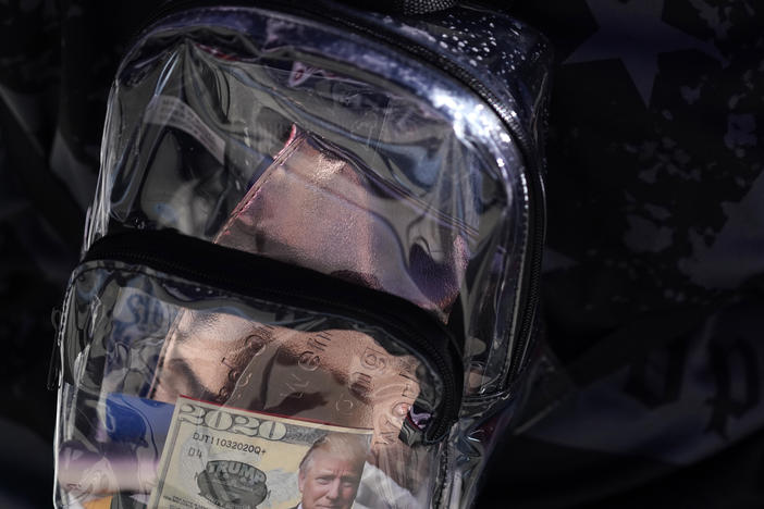 A supporter of President Donald Trump has a clear plastic backpack during a campaign rally at MBS International Airport, Thursday, Sept. 10, 2020, in Freeland, Mich.