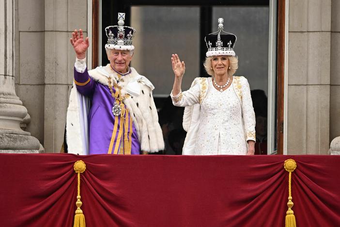 Britain's King Charles III wearing the Imperial state Crown, and Britain's Queen Camilla wearing a modified version of Queen Mary's Crown wave from the Buckingham Palace balcony after viewing the Royal Air Force fly-past in central London on Saturday.