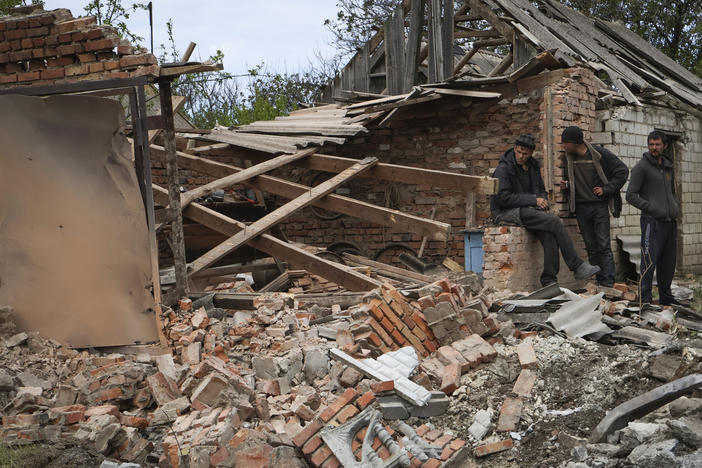 Residents stand next to a building that was damaged in the night, following Russian shelling in Komyshevakha, Zaporizhzhia region, Ukraine, Monday.