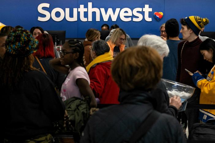 Travelers wait in line at the Southwest Airlines ticketing counter at Nashville International Airport after the airline cancelled thousands of flights in Nashville, Tennessee, on December 27, 2022.