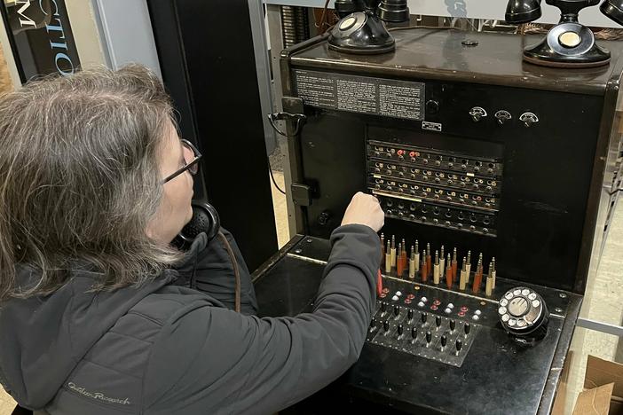 A visitor at the Connections Museum works the kind of switchboard system that first connected American phone users.