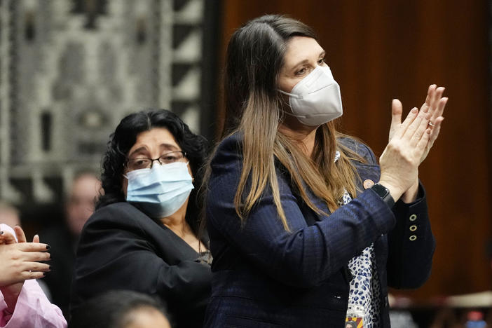 Democratic state Sen. Stephanie Stahl Hamilton (right) stands and applauds as Arizona Democratic Gov. Katie Hobbs gives the state address at the Arizona Capitol in Phoenix on Jan. 9.