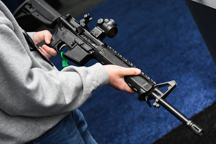 An attendee holds a Springfield Armory SAINT AR-15-style rifle displayed during the National Rifle Association Annual Meeting in Houston in 2022.