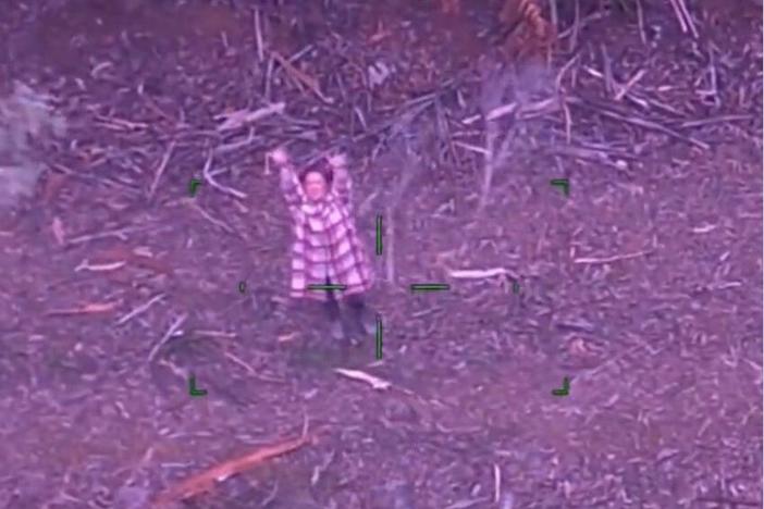 A screenshot shows the moment Lillian, a 48-year-old Australian woman, was rescued after going missing in dense bushland with only a bottle of wine and some candy.