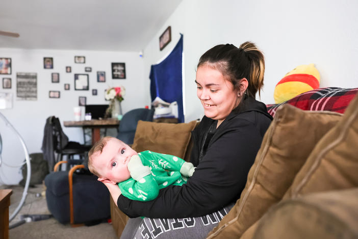 Jade Vandiver holds her son Ezra at home in Clayton, New Mexico. Vandiver joined a federally funded rural maternity program while pregnant with Ezra.