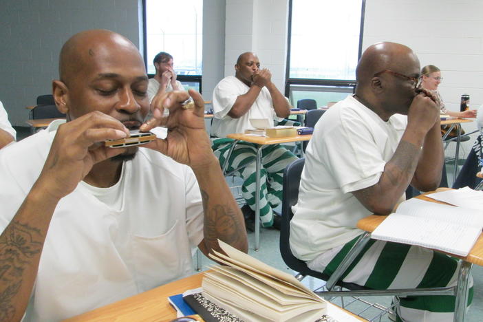 Inmate/students practice blues harmonica during a classroom session of the Blues Tradition in American Literature course inside Parchman Prison in Mississippi.