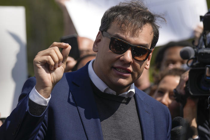 U.S. Rep. George Santos, R-N.Y., speaks to the media outside the federal courthouse in Central Islip, N.Y., Wednesday. The next day, he appeared virtually in a Brazilian court to face separate charges.