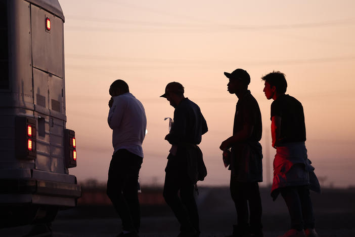 Immigrants seeking asylum wait to board a bus to a U.S. Border Patrol processing center, after crossing into Arizona from Mexico, on Thursday in Yuma, Ariz.