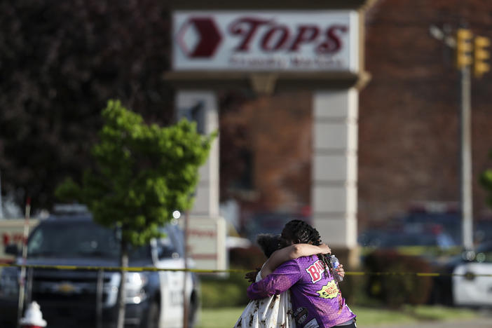 People hug outside the scene after a shooting at a supermarket on May 14, 2022, in Buffalo, N.Y.