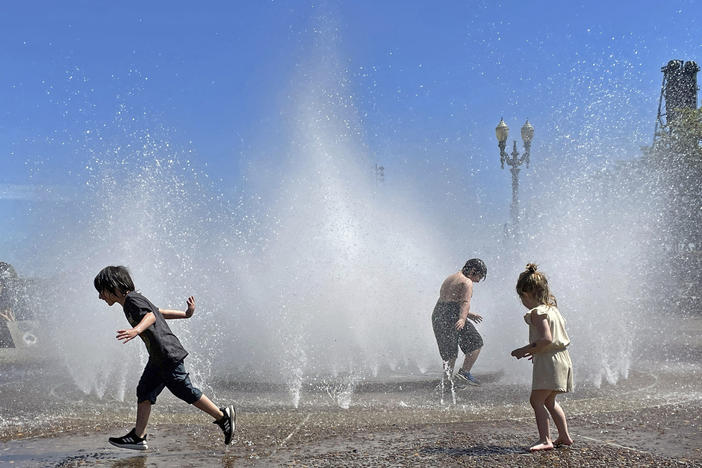 Children play in a fountain to cool off in downtown Portland, Ore., Friday, May 12, 2023. An early May heat wave this weekend could surpass daily records in parts of the Pacific Northwest and worsen wildfires already burning in western Canada, a historically temperate region that has grappled with scorching summer temperatures and unprecedented wildfires fueled by climate change in recent years.