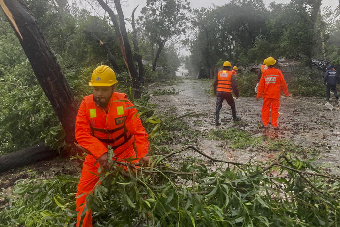 Rescue workers remove the fallen tress after a storm in Teknaf, near Cox's Bazar, Bangladesh, Sunday, May 14, 2023. Bangladesh and Myanmar braced Sunday as a severe cyclone started to hit coastal areas and authorities urged thousands of people in both countries to seek shelter.