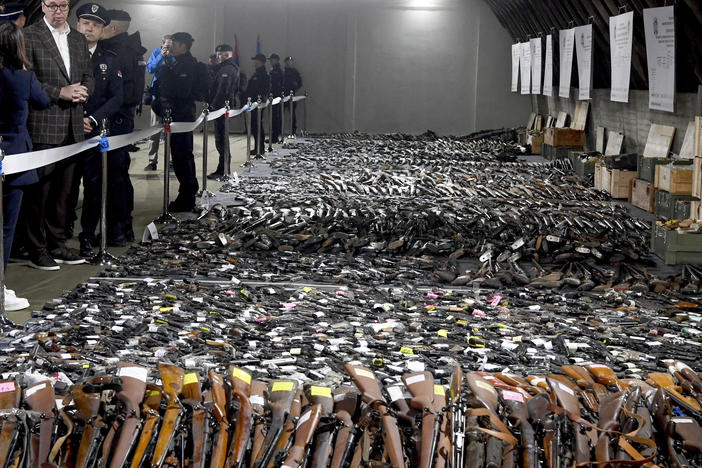 In this photo provided by the Serbian Presidential Press Service, Serbian President Aleksandar Vucic, left, inspects weapons collected as part of an amnesty near the city of Smederevo, Serbia, Sunday, May 14, 2023.