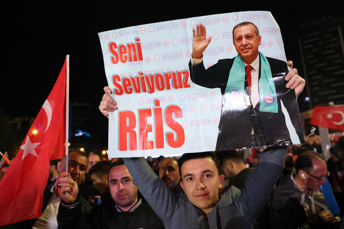 A supporter of Turkish President Tayyip Erdogan holds a poster which reads "We Love You Chief" outside the AK Party headquarters after polls closed in Turkey's presidential and parliamentary elections in Ankara, Turkey on Monday.
