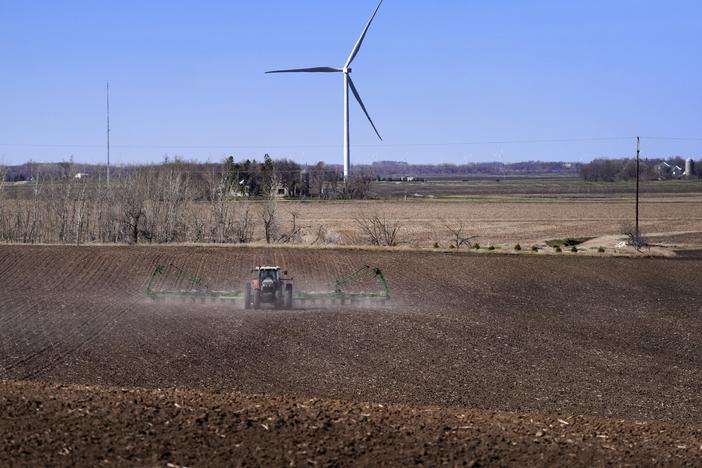 Corn is planted with a view of wind turbines on April 2, in Lake Benton, Minn. The U.S. Department of Agriculture announced a nearly $11 billion investment on Tuesday to help bring affordable clean energy to rural communities throughout the country.