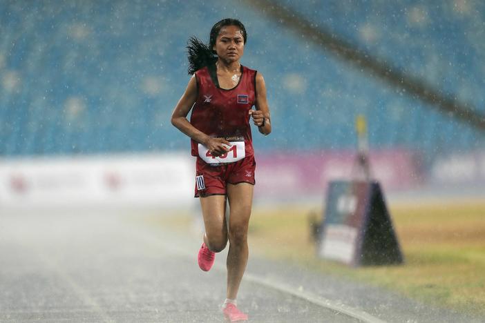 Cambodia's Bou Samnang runs in the women's 5,000-meter final despite heavy rain, during the Southeast Asian Games in Phnom Penh. A video of her finish, minutes after the race was decided, has won over fans around the sporting world.