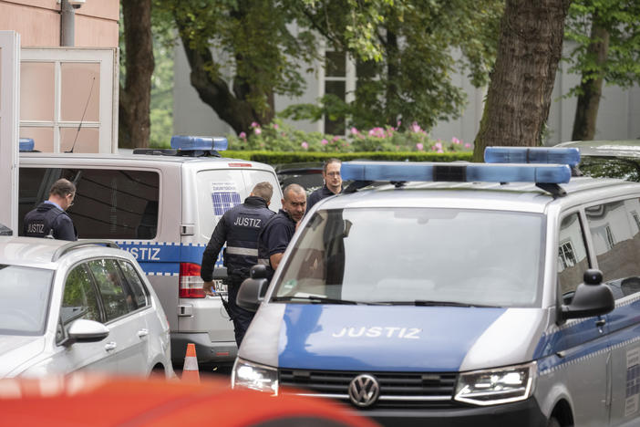 Two judiciary vans, each carrying defendants, drive in a courtyard before the start of the trial against members of the "United Patriots" grouping at the Higher Regional Court in Koblenz, Germany, Wednesday, May 17, 2023.