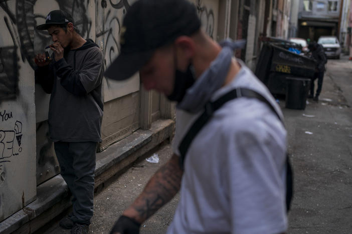 Two men smoke fentanyl in an alley in Los Angeles on April 18, 2022. The latest federal data show more than 109,000 drug deaths in 2022, many from fentanyl.