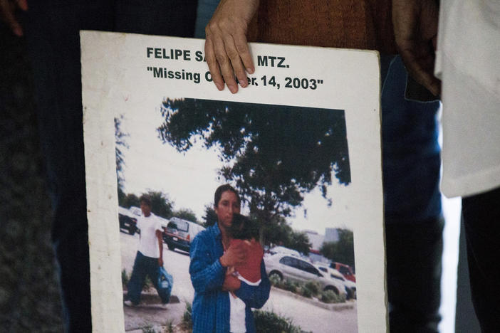A woman holds a sign for Felipe Santos during a remembrance ceremony for missing persons at Cambier Park in Naples on Oct. 25, 2017.