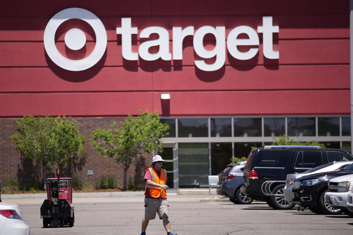 A worker collects shopping carts in the parking lot of a Target store on June 9, 2021, in Highlands Ranch, Colo.