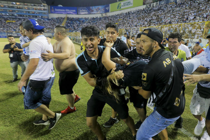 An injured fan in carried to the field of Cuscatlan stadium in San Salvador, El Salvador, Saturday, May 20, 2023. At least nine people were killed and dozens more injured when stampeding fans pushed through one of the access gates at a quarterfinal Salvadoran league soccer match between Alianza and FAS.