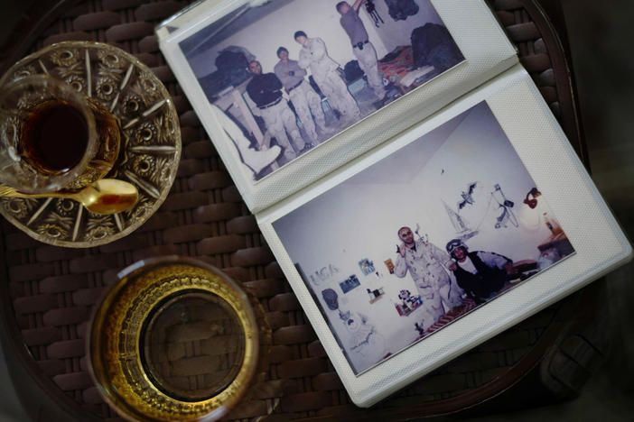A photo album of Shihab — during his time as an interpreter working with American military personnel during the Iraq War — rests on a small table alongside cups of tea.