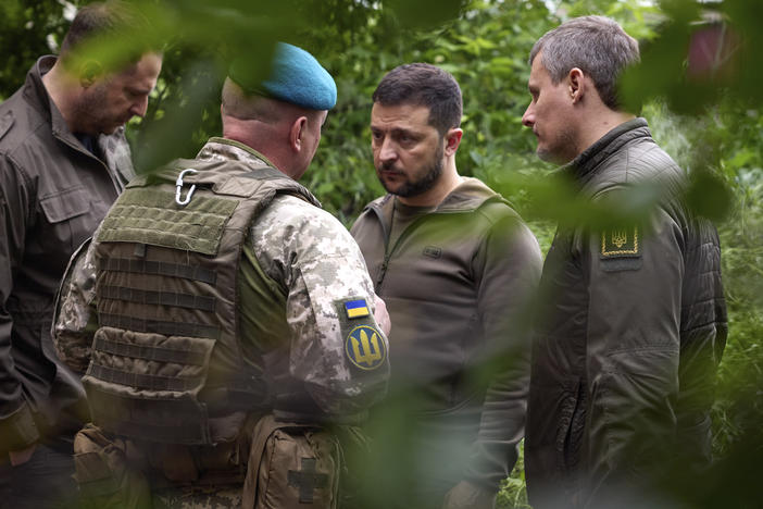 Ukrainian President Volodymyr Zelenskyy listens to military commanders as he visits the eastern Donetsk region, an area of heavy fighting, on Tuesday. Zelenskyy and other Ukrainian officials say a major military offensive is likely to start soon.