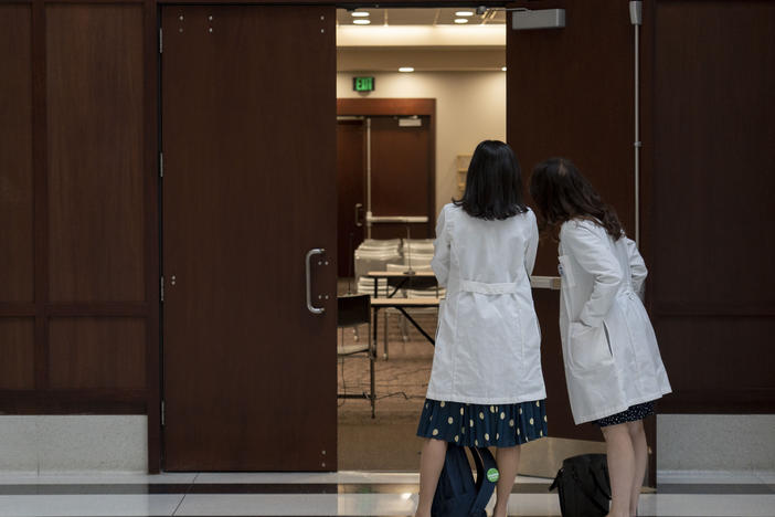 Dr. Tracey Wilkinson, left, a pediatric doctor with IU School of Medicine, and Dr. Caroline E. Rouse, a maternal fetal medicine doctor with IU School of Medicine, line up outside of a conference room to support Dr. Caitlin Bernard on Thursday, May 25, 2023 in Indianapolis.