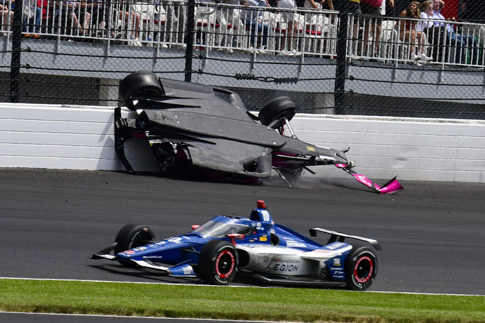 The car driven by Kyle Kirkwood, top, flips over after a crash in the second turn during the Indianapolis 500 auto race at Indianapolis Motor Speedway on Sunday.