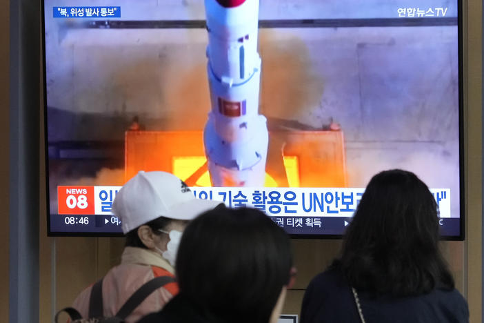 A TV screen shows a file image of North Korea's rocket launch during a news program at the Seoul Railway Station in Seoul, South Korea, on Monday.