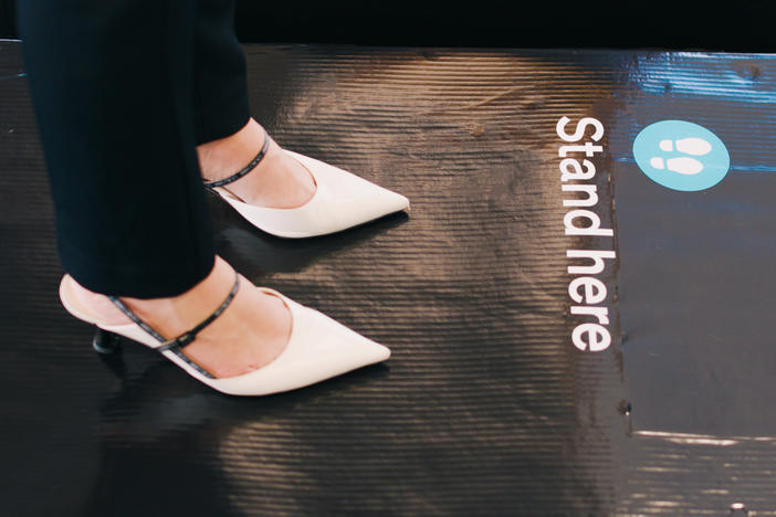 A passenger stands on scales at Auckland International Airport as part of a survey to generate average weights for people traveling on Air New Zealand flights.