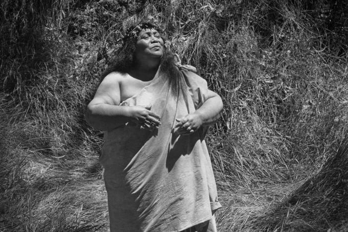 Edith Kanakaʻole chants in the koa forest of Kīpukapuaulu in Hawai'i Volcanoes National Park in 1977. She titled the photo "The Growth of Love is the Essence Within the Soul."