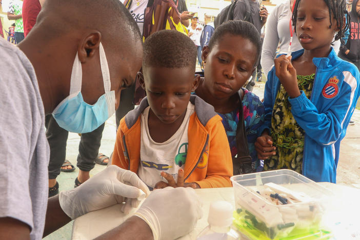 People queue for a free malaria test in Lagos, Nigeria. The country has one of the highest national death tolls from the mosquito-borne disease. A new vaccine offers hope. But logistics could prevent it from reaching the arms of those who are eligible.