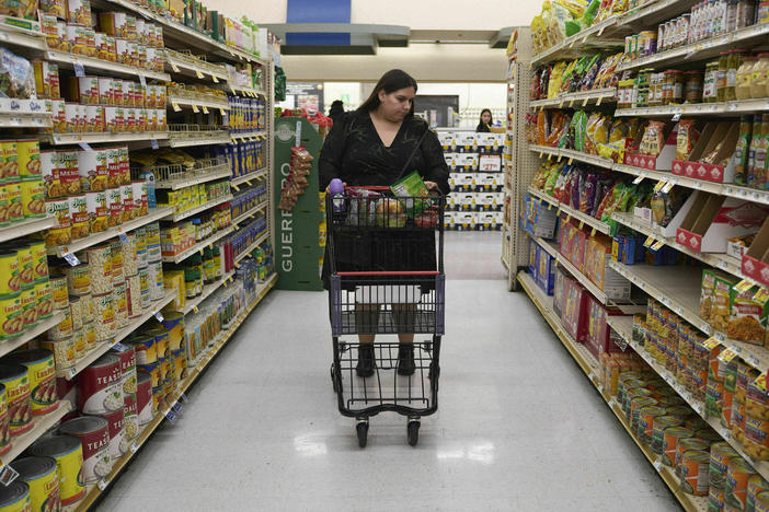 Jaqueline Benitez pushes her cart down an aisle as she shops for groceries at a supermarket in Bellflower, Calif., on Monday, Feb. 13, 2023. Benitez, 21, who works as a preschool teacher, depends on California's SNAP benefits to help pay for food.