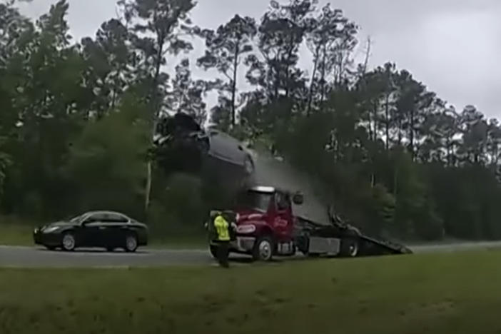 First responders who were clearing a crash on a Georgia highway witnessed a scary spectacle, when a motorist drove onto a tow truck's lowered ramp at speed.