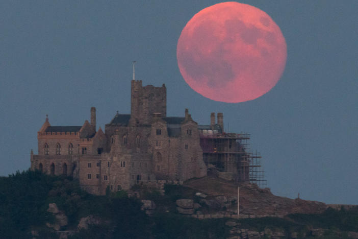 The strawberry moon rises behind St Michael's Mount in Marazion near Penzance on June 28, 2018, in Cornwall, England.