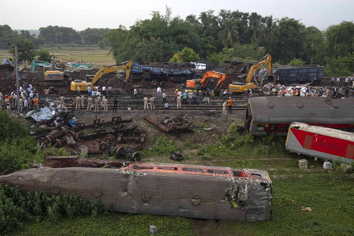 People watch at the site where trains that derailed, in Balasore district, in the eastern Indian state of Orissa, Sunday, June 4, 2023.