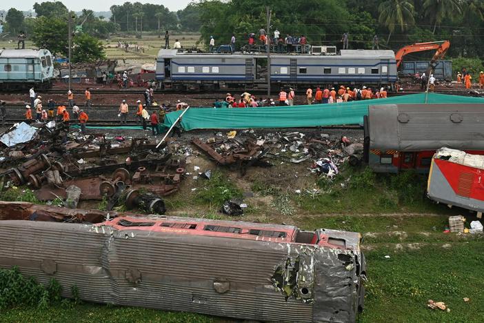 Railway workers help to restore services at the accident site of a three-train collision near Balasore, India, on Sunday.