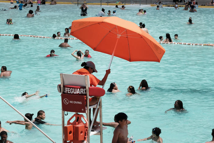 A lifeguard watches as people cool off in a public swimming pool in 2021 in the Astoria neighborhood of Queens in New York City.