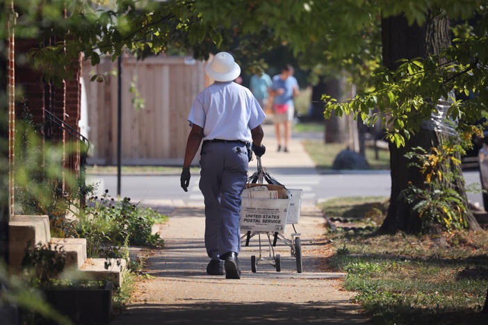 A postal worker delivers mail on October 1, 2021 in Chicago, Illinois.