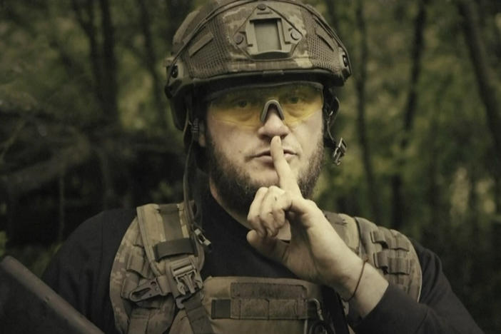In this image made from video provided by the Ukrainian Defense Ministry on Sunday, a Ukrainian soldier poses for the camera with his finger to his lips. The video shows troops gesturing for silence suggesting that no formal announcement of a possible counteroffensive against Russia will be made. Text appears in the video saying: "Plans love silence. There will be no announcement of the start."