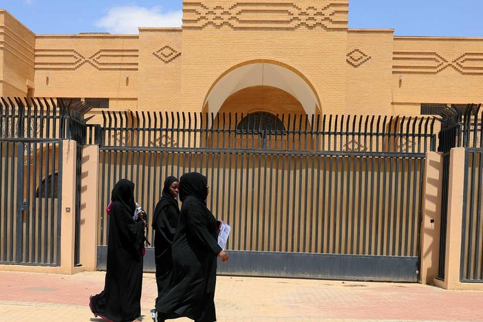 Women walk past the closed Iranian embassy in the diplomatic quarter of the Saudi capital Riyadh, on April 11.