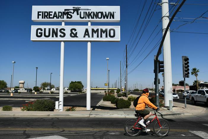 The silhouette AR-15-style rifle is displayed on signage for the Firearms Unknown Guns & Ammo gun store in Yuma, Ariz., last week.