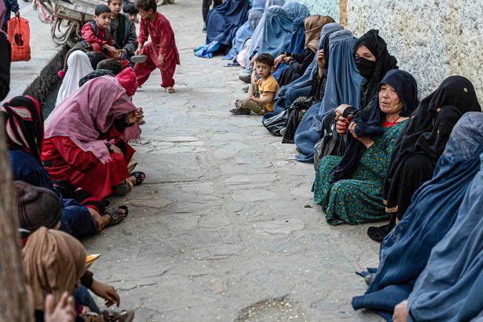 Afghan women wait for a free bread. Charities allege that the Taliban interferes with their distribution of aid by pressuring them to funnel money to the Taliban and its supporters.