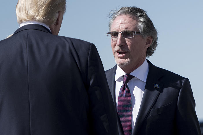 In this September 6, 2017 photo, North Dakota Governor Doug Burgum greets US President Donald Trump after his arrival at Bismarck Municipal Airport in Bismarck, North Dakota.