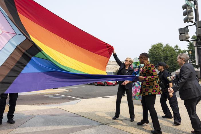 Energy Secretary Jennifer Granholm, center, helps raise a Pride flag outside of the Department of Energy as the Biden administration celebrates Pride Month.